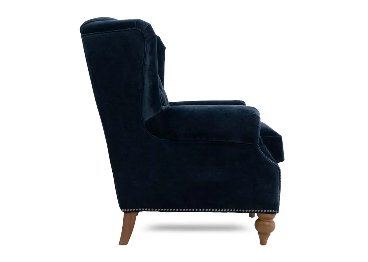 A blue fabric wing chair with stud detail from EZ Livings Adare range. Side view