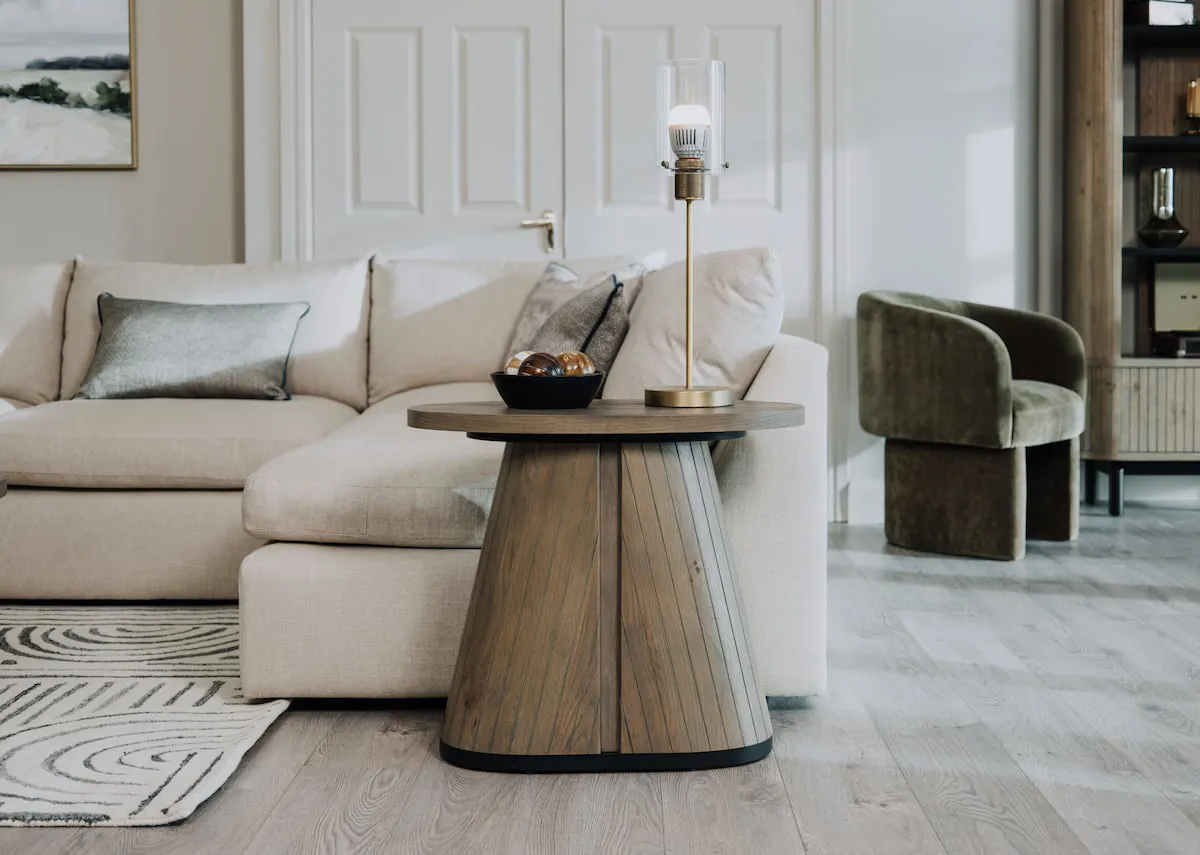 A lifestyle image of the Bunratty sofa with Vega grey lamp table with Karina brass lamp