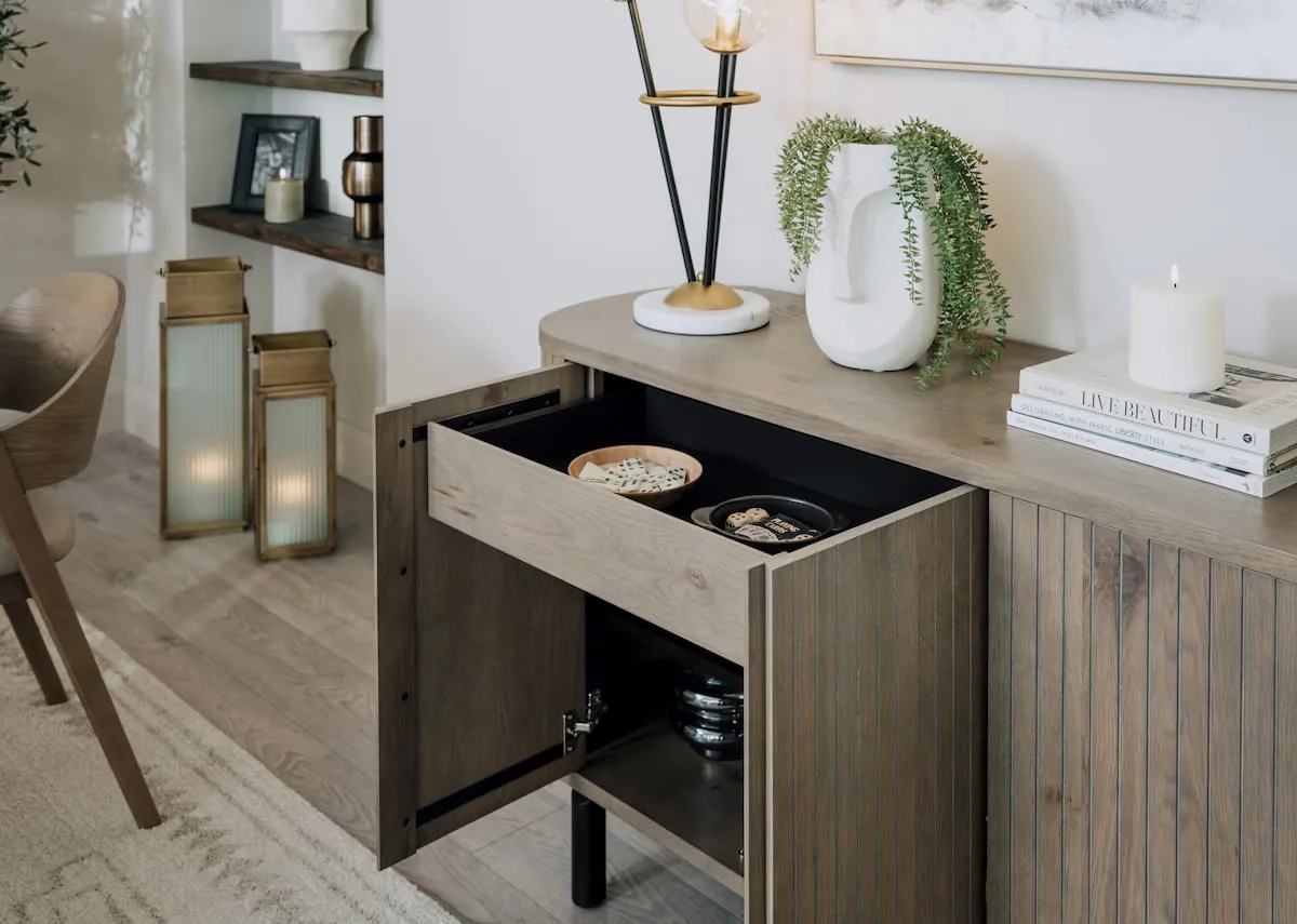 A lifestyle image of the Vega sideboard with doors open showing storage space