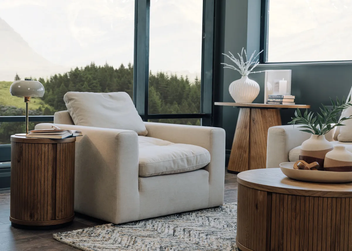 A lifestyle image of the Cozy armchair with Vega side table with table lamp