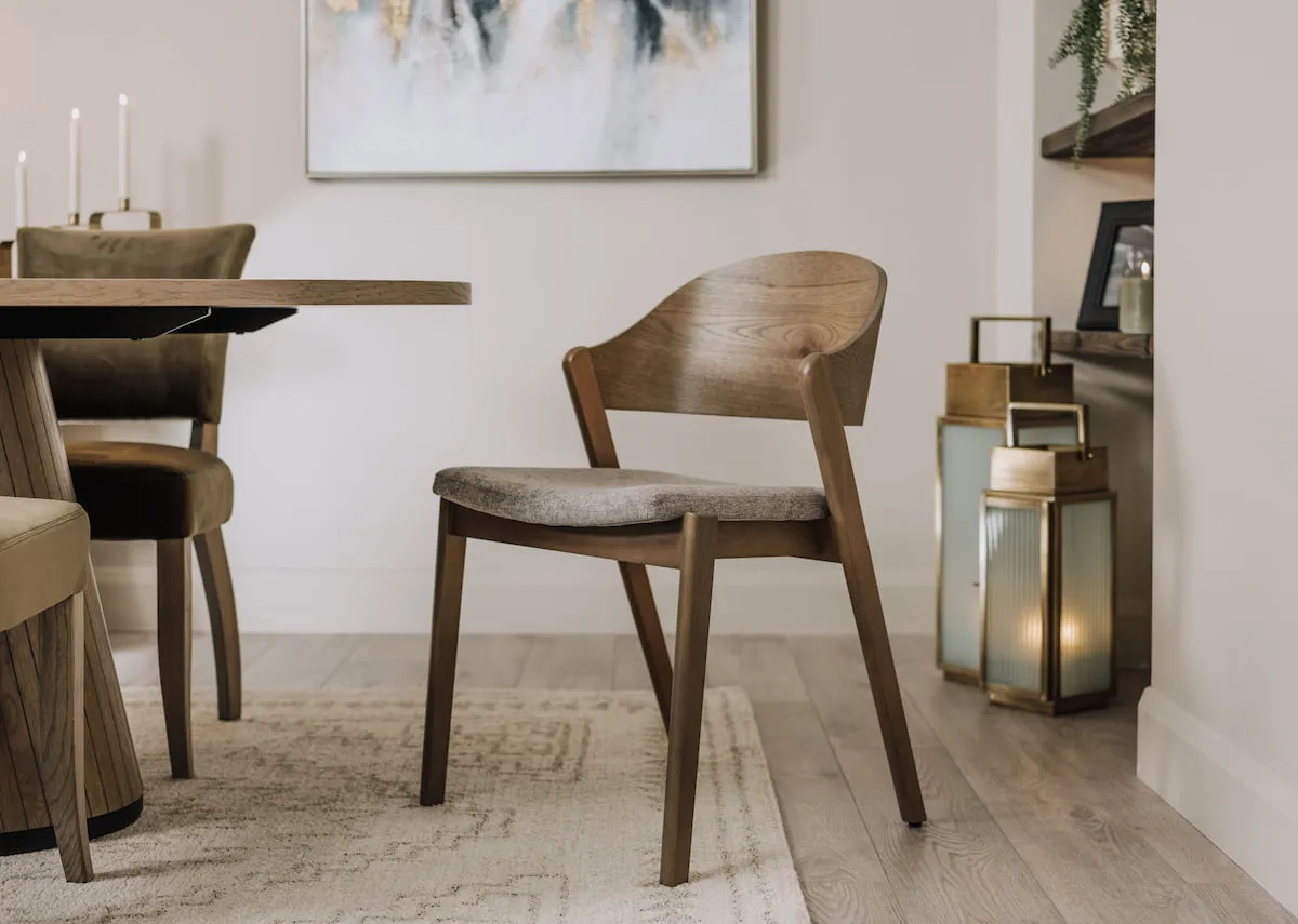 A lifestyle image of the Vega dining chair with grey fabric seat