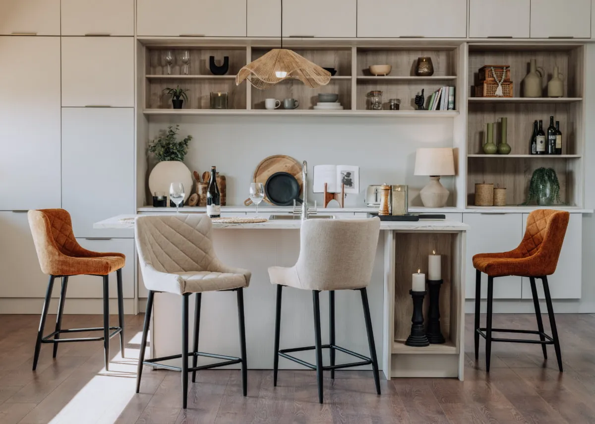 A cream kitchen with 2 ottowa cream and 2 gold bar stools.