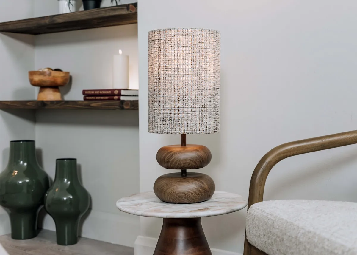A lifestyle image of the Nixie table lamp with slade tables and green vases