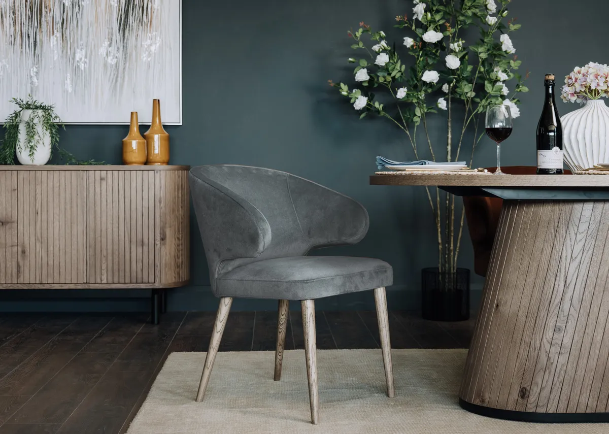 A lifestyle image of the Visot dining chair with grey leg and Vega grey tabzle.