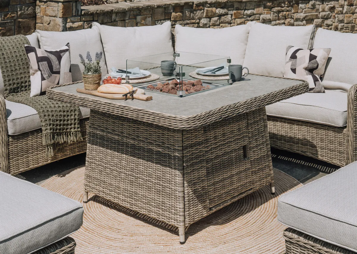 A closeup lifestyle image of the Firepit with carcoals on the Monterey corner ste.