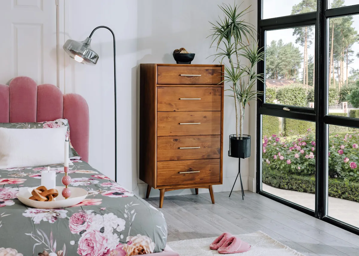 A lifestyle image of the Leya tallboy with Faye pink bed and Camila floor lamp