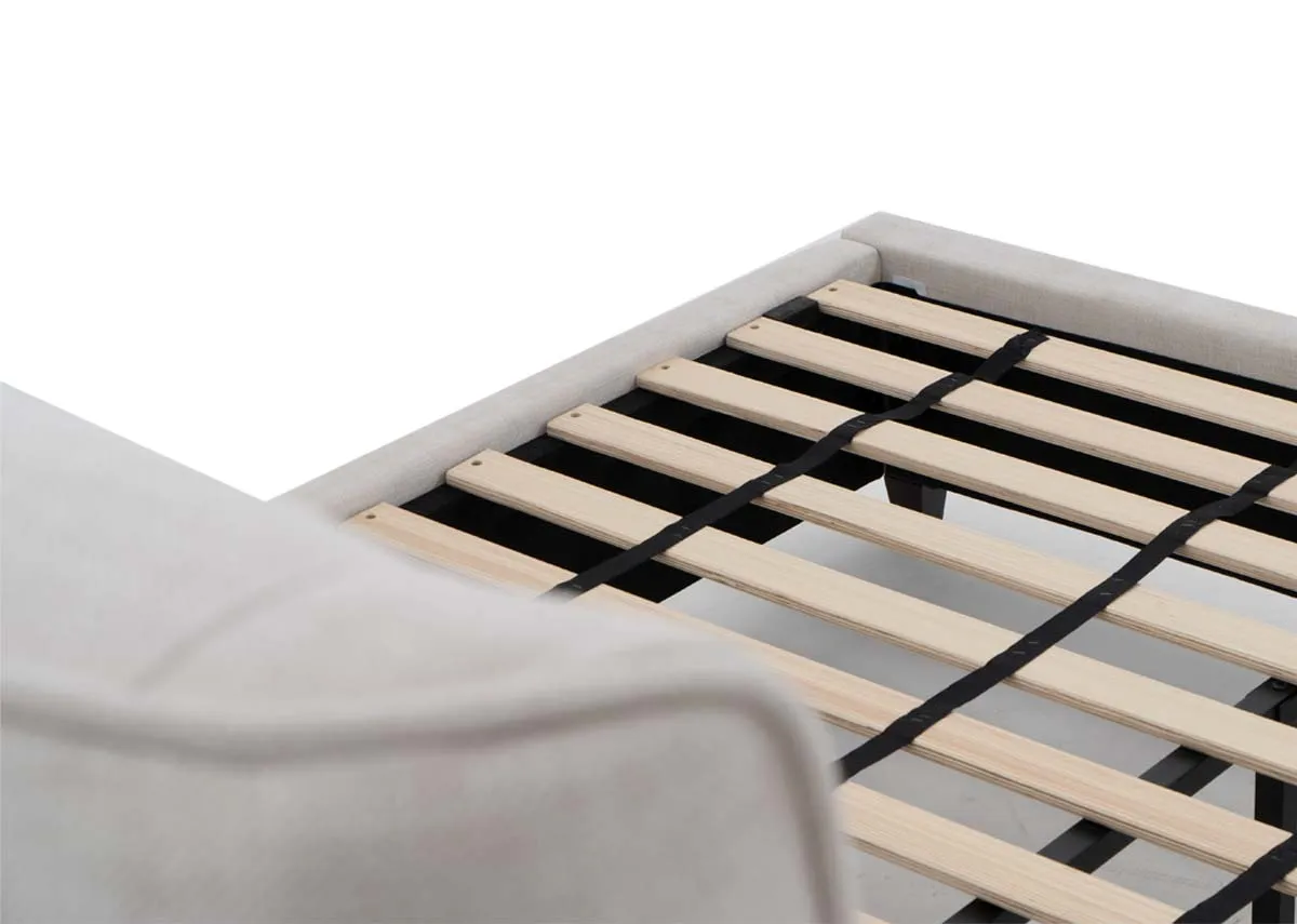 A beige fabric bed frame from EZ Livings Saoirse range. Closeup of slat wood base
