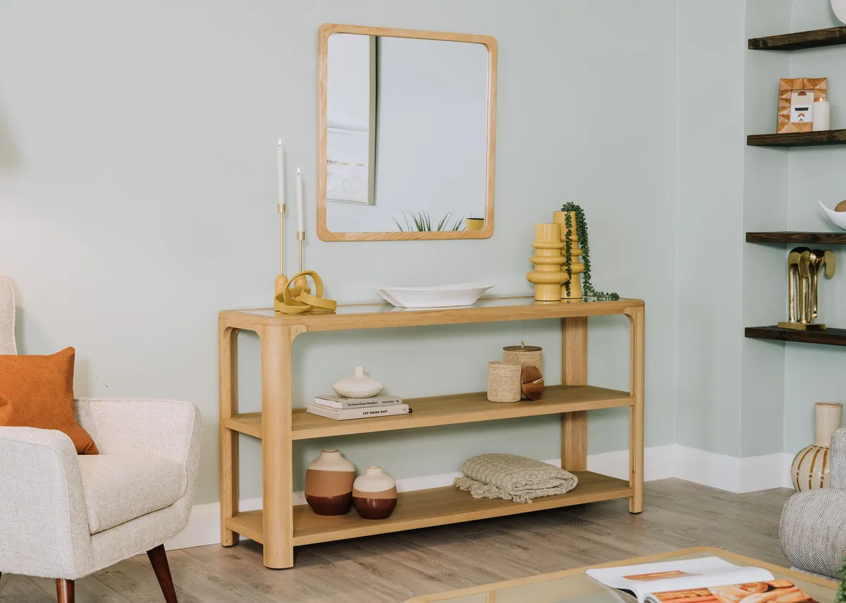 A lifestyle image of the Gus Console table with Wood mirror and a selection of accessories