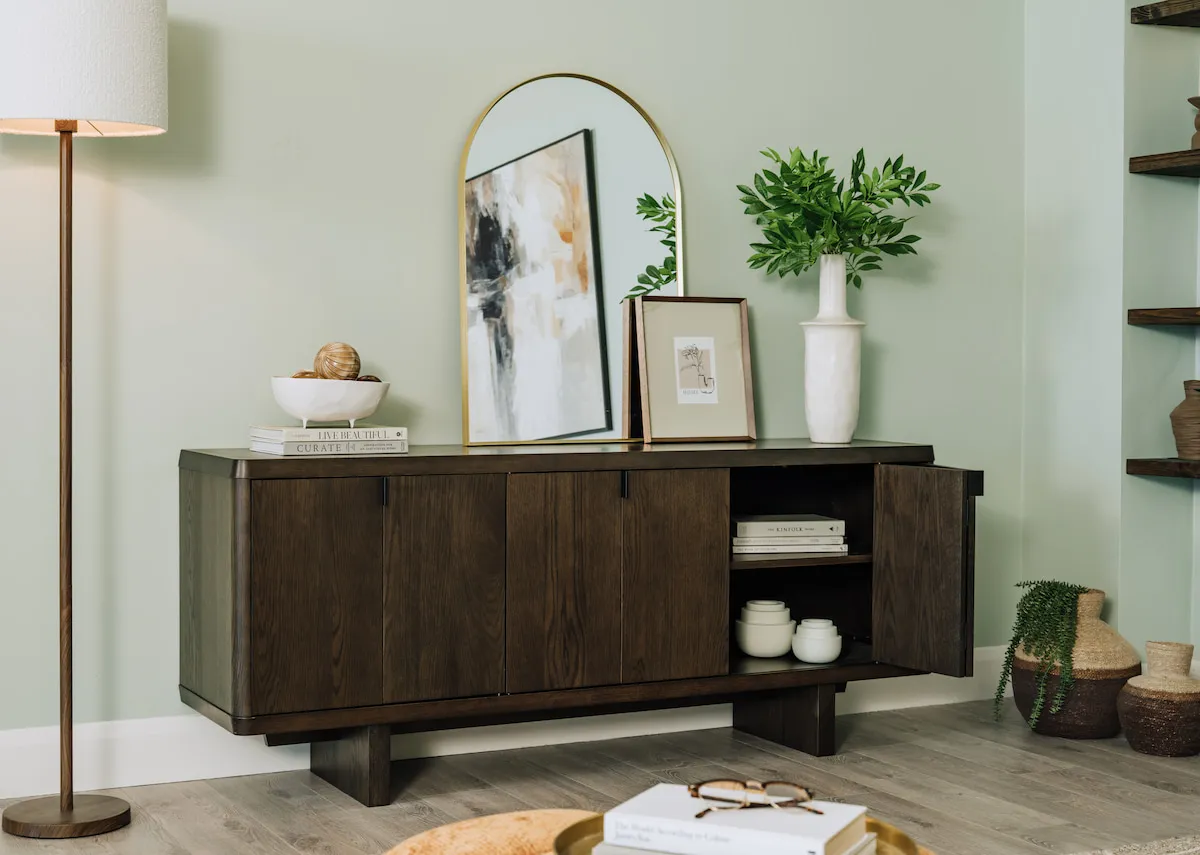 A lifestyle image of the Rimini sideboard with door open showing storage Washington lamp and Flynn mirror.