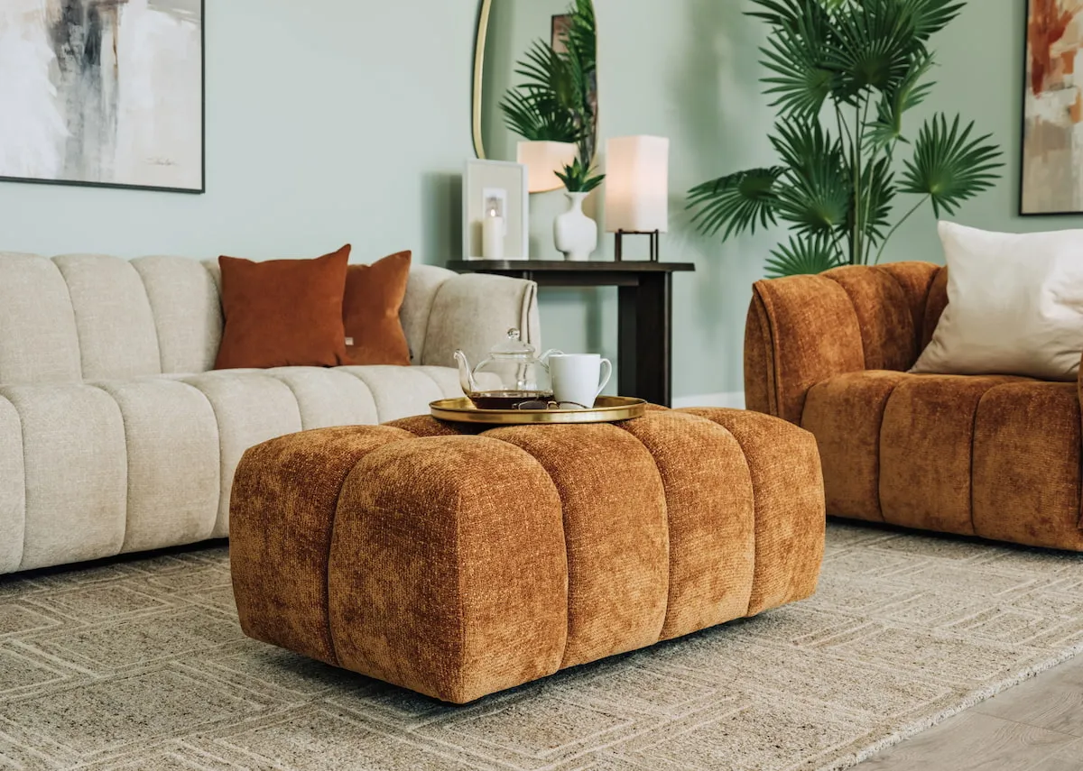 A lifestyle image iof the Matera footstool with ivory sofa and memphis rug.