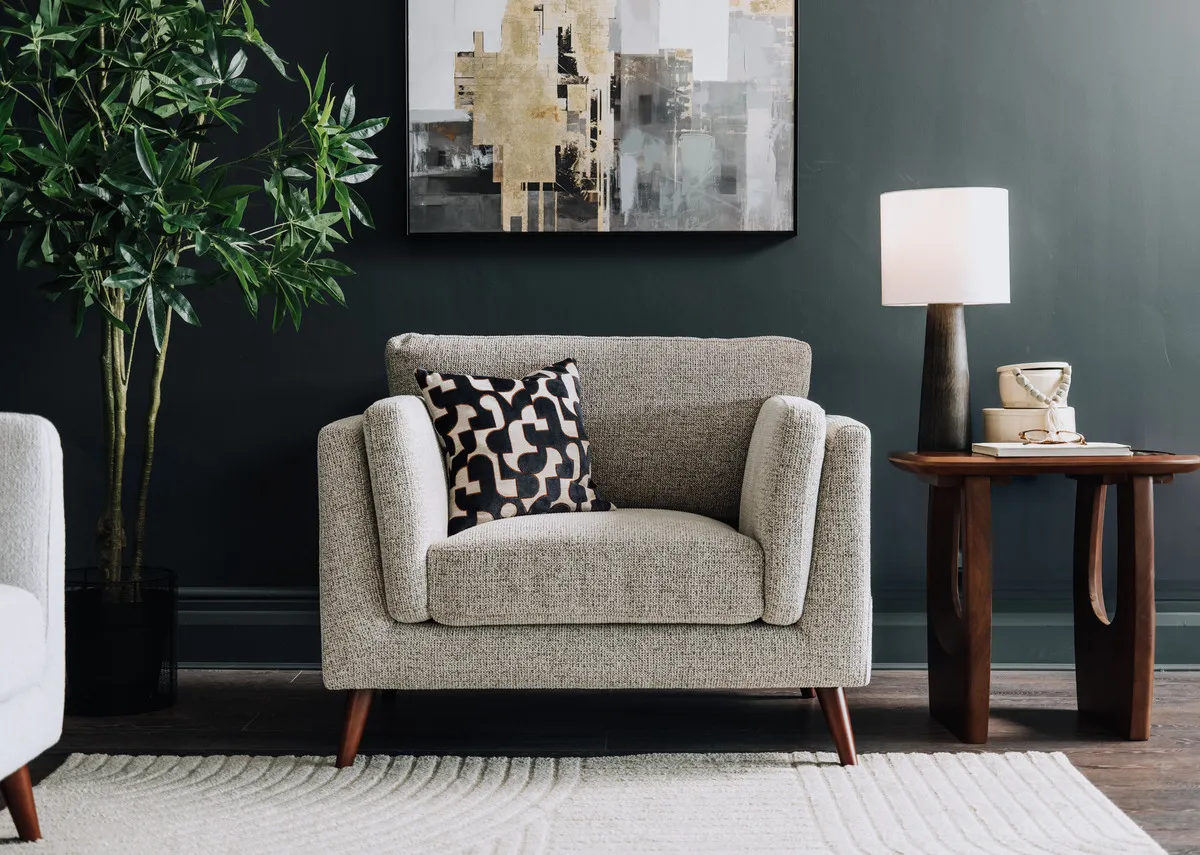 A lifestyle image of the Bailey Armchair with jet lamp table with Liberty canvas and tate lamp.