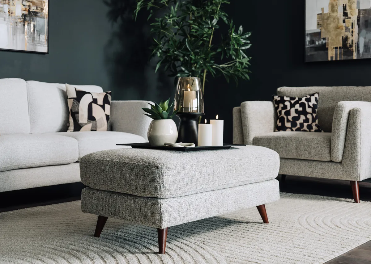 A lifestyle image of the Bailey Footstool with matching armchair.
