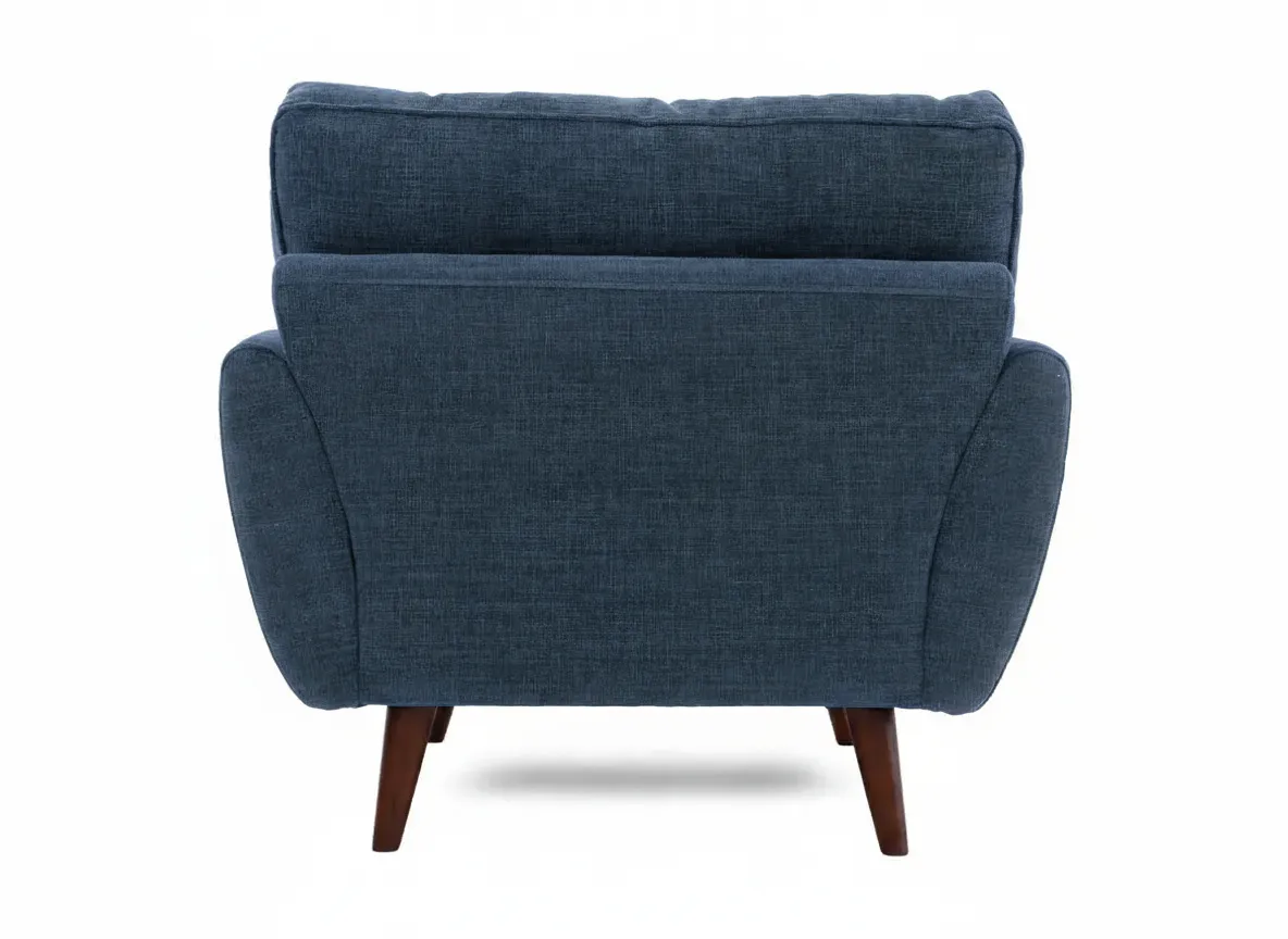 The back view of a blue fabric armchair showing its solid back panel and four tapered wooden legs.