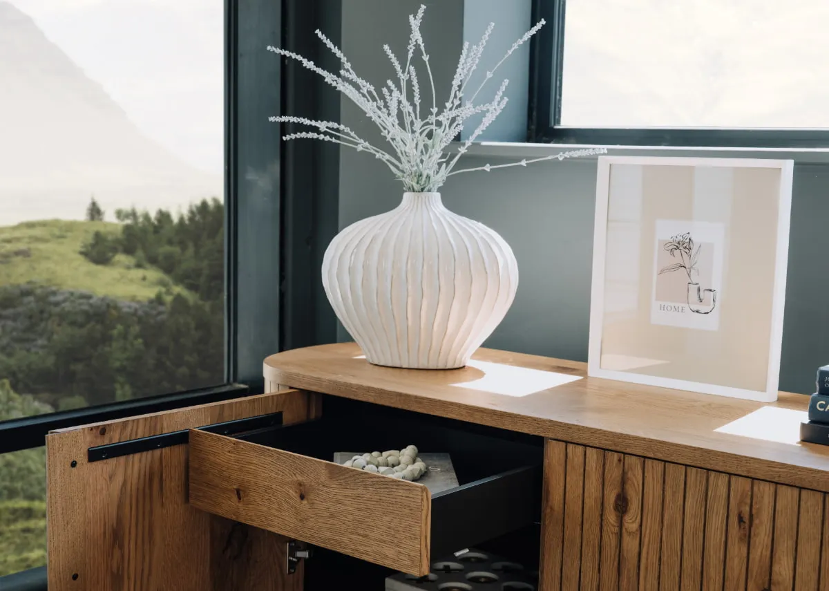 A lifestyle image of the Lorito vase and Myla white photo frame on a vega sideboard.
