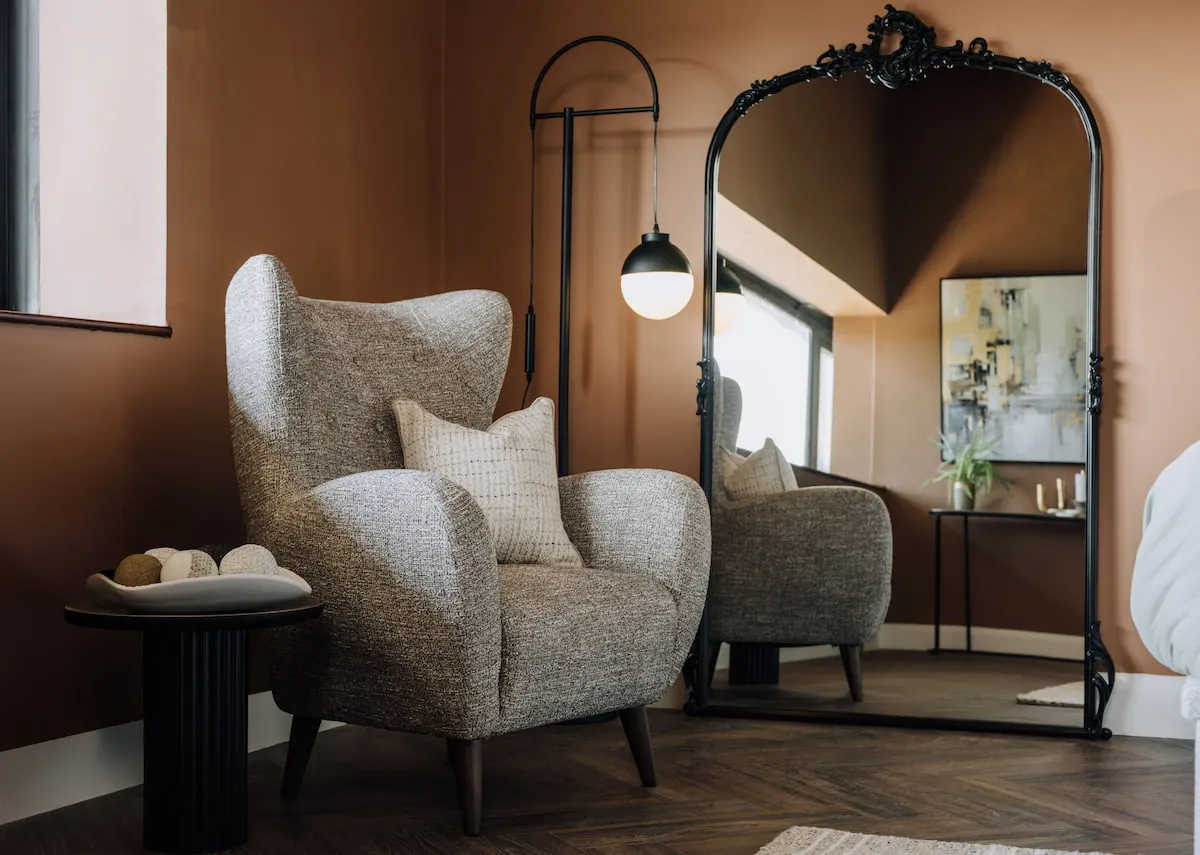 A lifestyle image of the Kacey Mirro with the Brox armchair with Casper floor lamp.