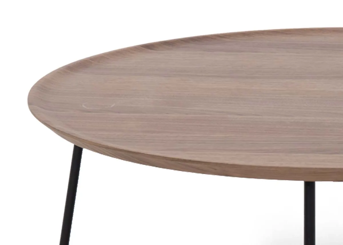 A round walnut veneer coffee table with metal legs from EZ Livings Bonita range.Closeup of walnut finish