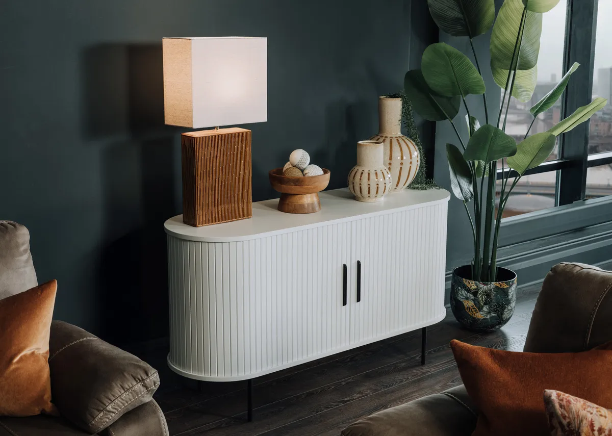A lifetsyle image of the Nola Sideboard with Dee table lamp and Emme pot with artificial plant