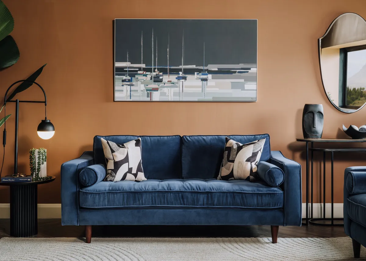A lifestyle image of the Genoa blue sofa with Harbourside canavs and casper lamp