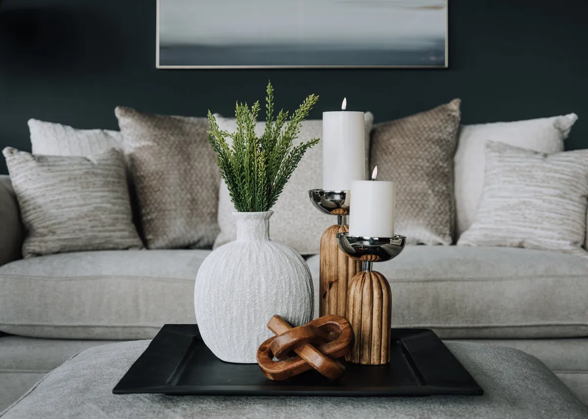 A lifestyle image of the Cremon vase with wooden candleholders on a coffee table.