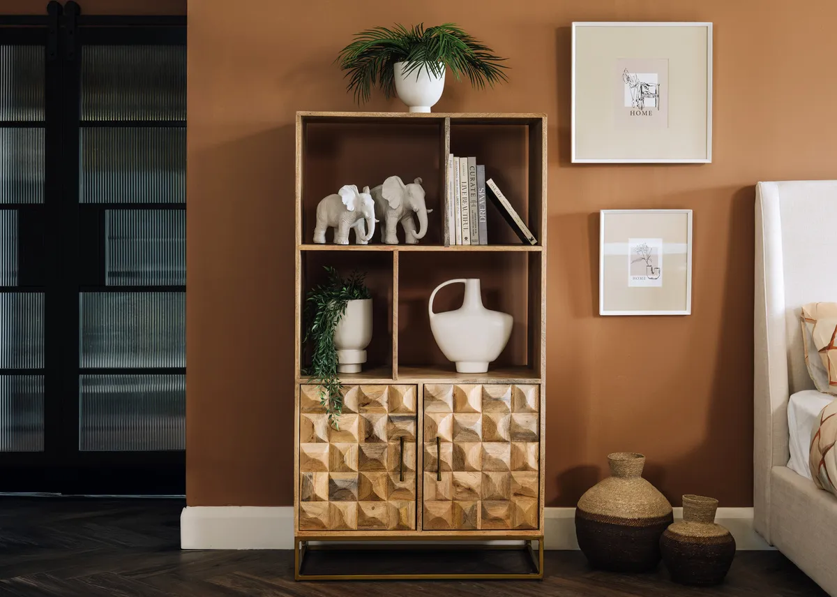 A lifestyle image of the Diva bookcase dressed with ornaments in a bedroom setting.