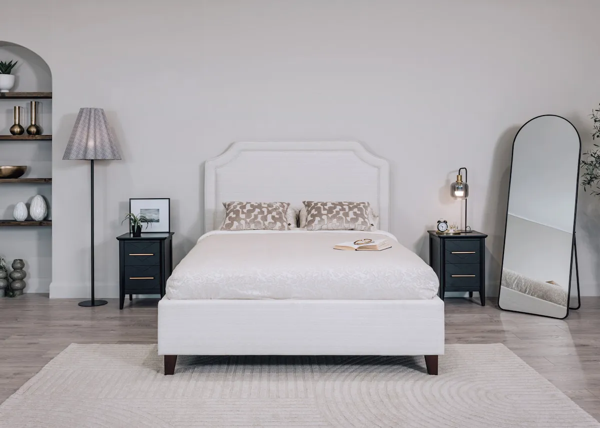 A lifetsyle image of the Archie bed with 2 carter natural cushions with the Rodrigo lamp.