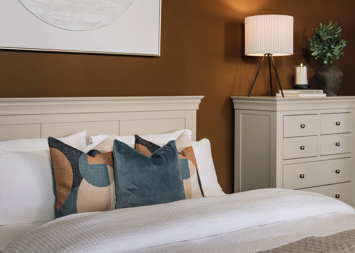 A lifestyle image of the Dove bedframe with richelle sapphire cushion and Mid century cushion.