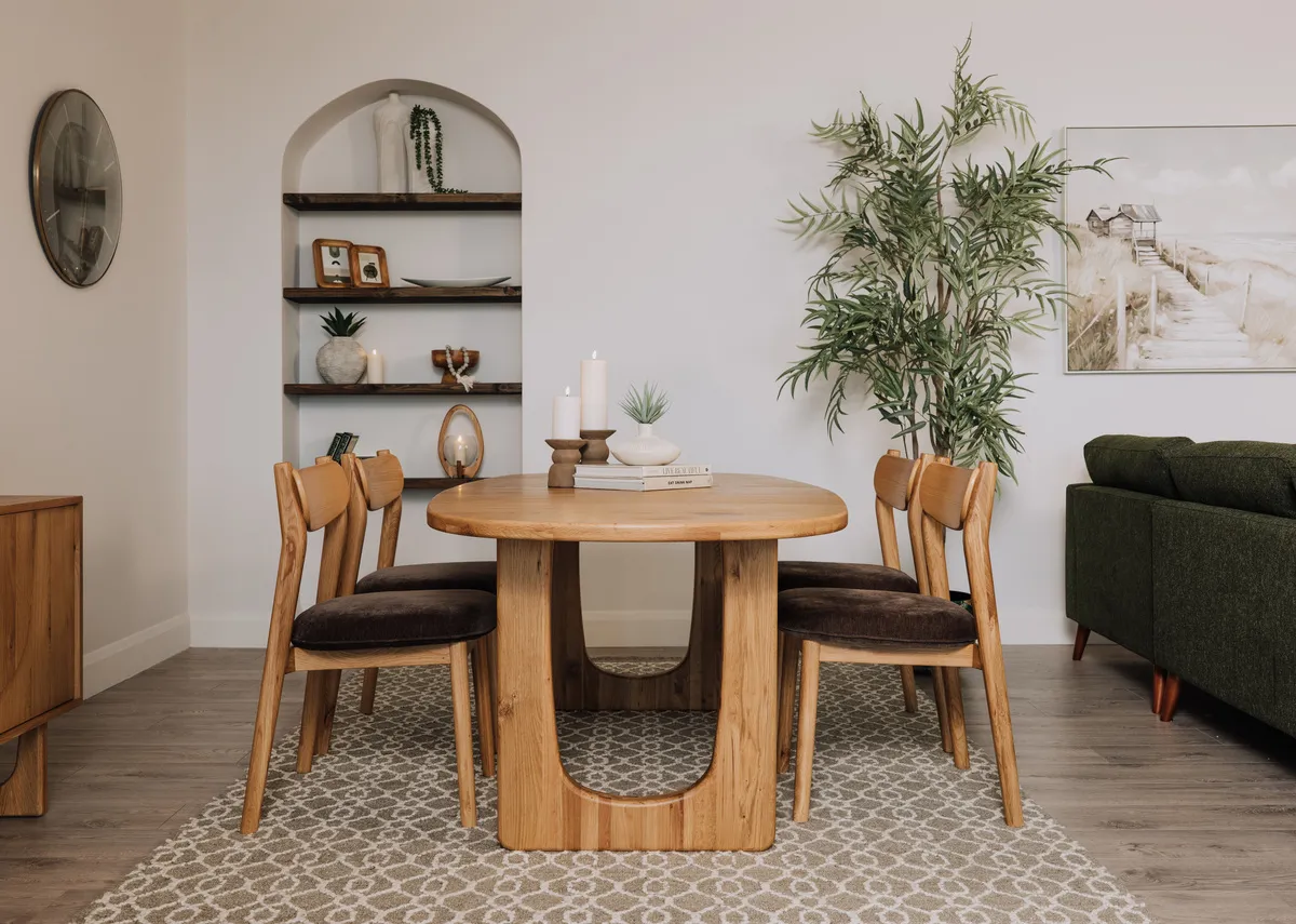 A lifestyle image of the Pierro dining table with dining chairs and Heiny rug