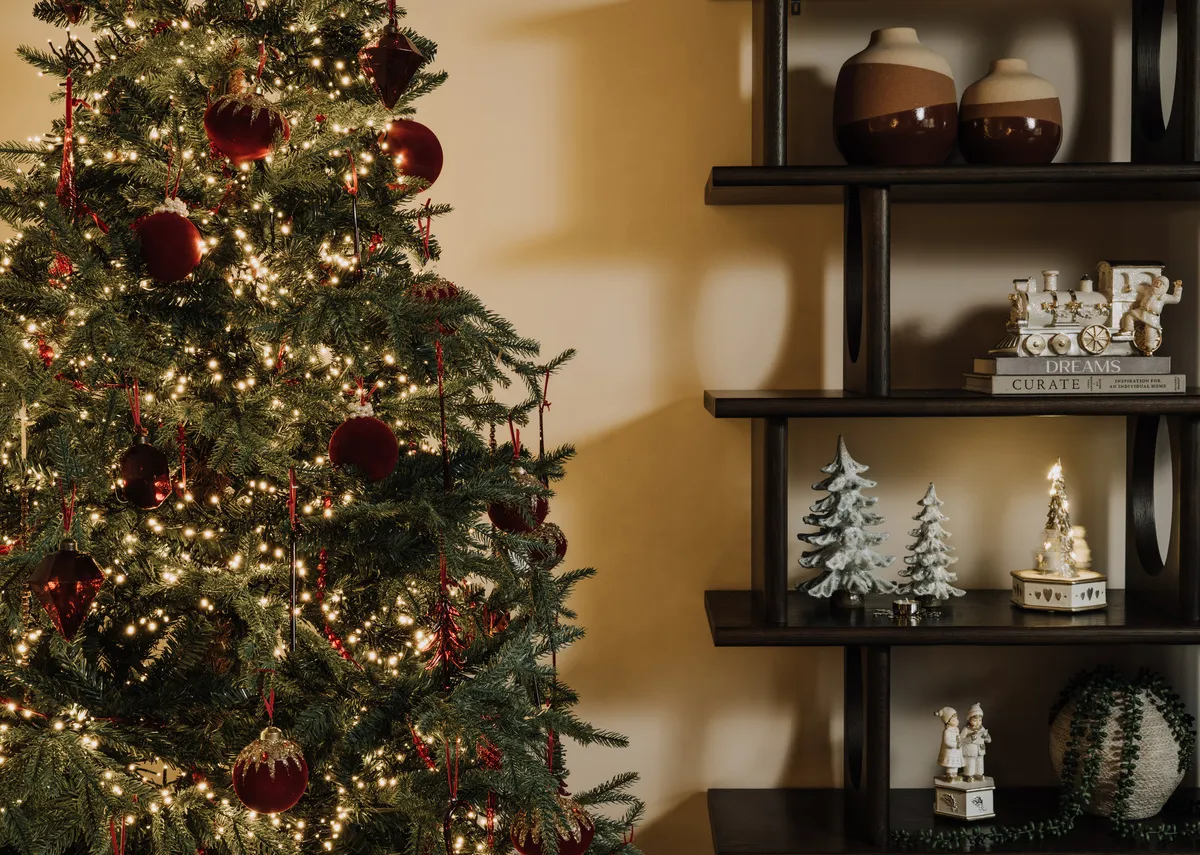 A lifestyle image of the Aspen tree with Flow display with Snow figurines including the Music box and LED Train & Xmas trees with snow.