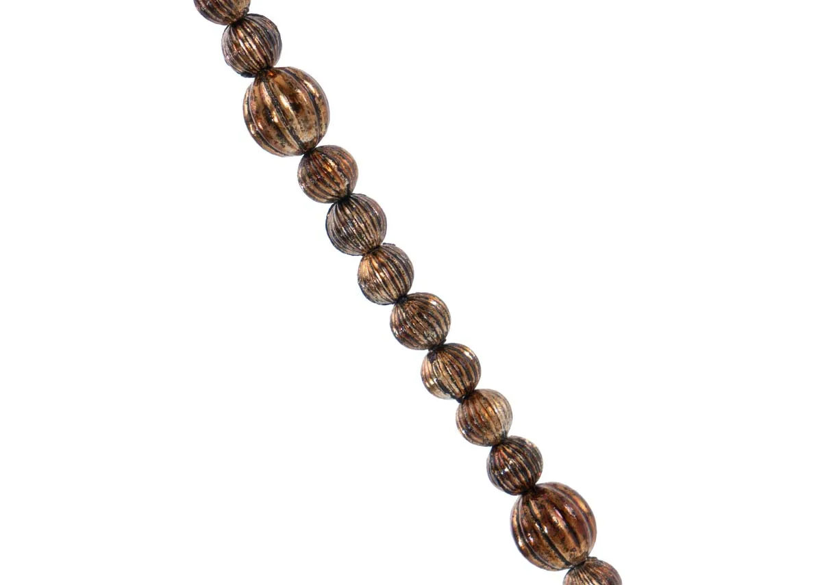 A close up of the textured brown beads on a brass large crystal garland showcasing their ribbed pattern and warm tone.