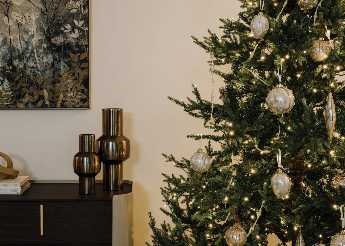A lifestyle image of the Aspen tree with a selection of gold baubles including the finial