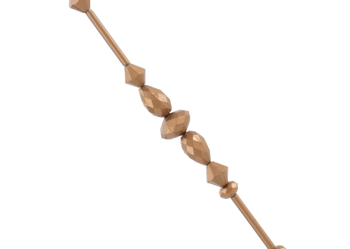 A close up of the faceted brass beads on a brass diamond garland showing their geometric shapes and warm metallic finish.