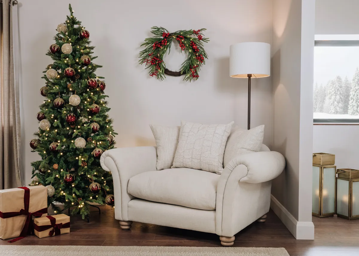A lifestyle image of the Olivia armchair with Austrai tree decorated with red & gold baubles