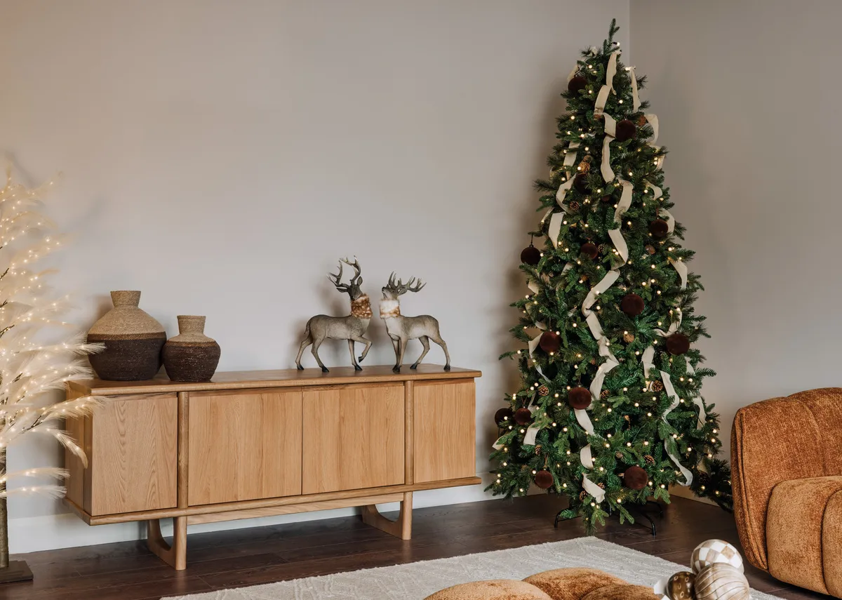 A lifestyle image of the Austria tree with brown baubles and Sideboard