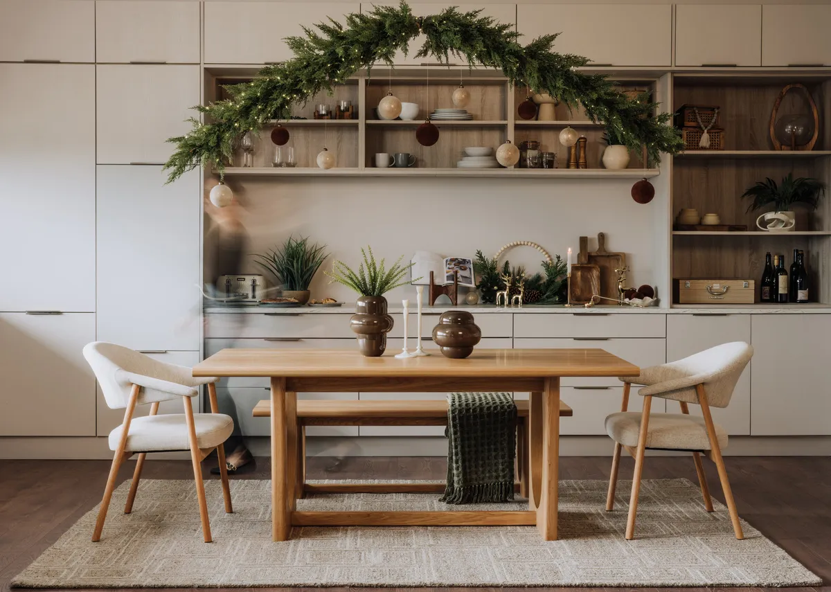 A lifestyle image of the North Garland with Lights over the Flow dining table with elk dining chairs