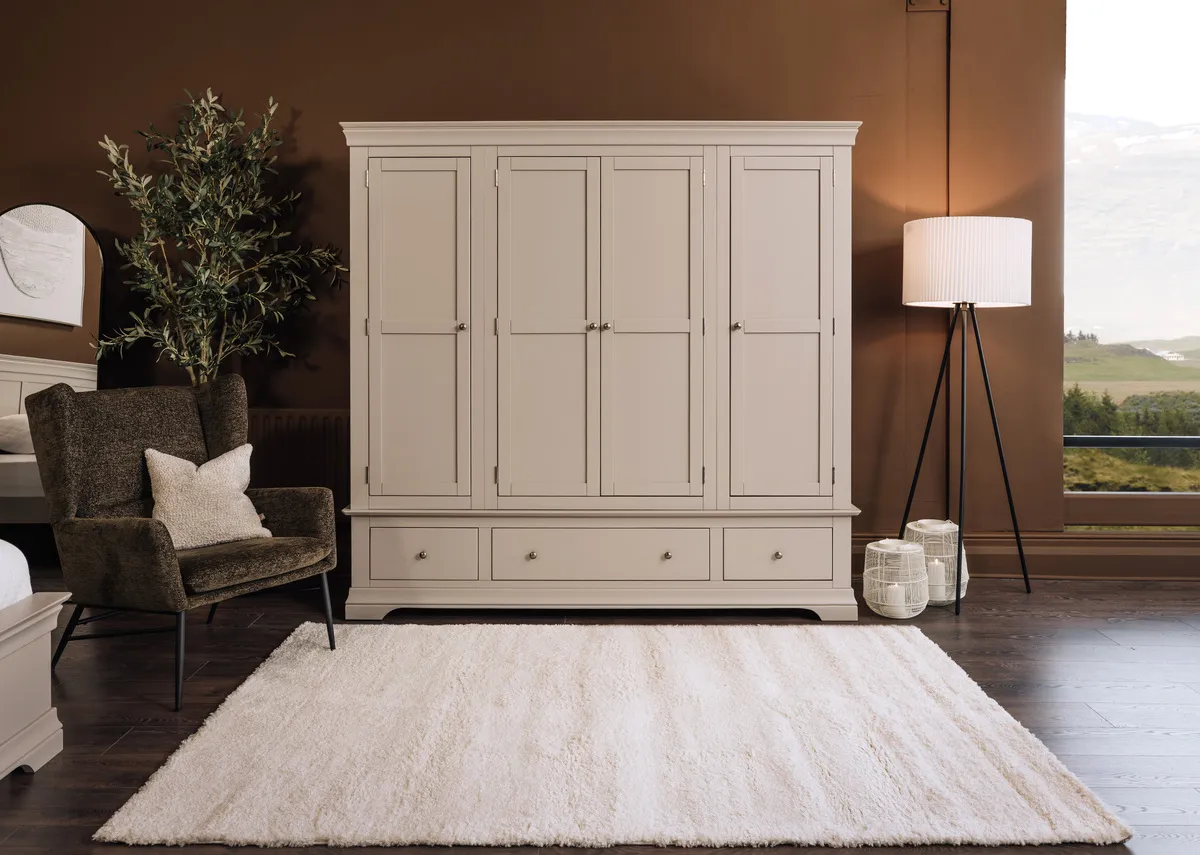 A lifebstyle image of the Dove wardrobe with the Boston  green chair with Vivo rug.