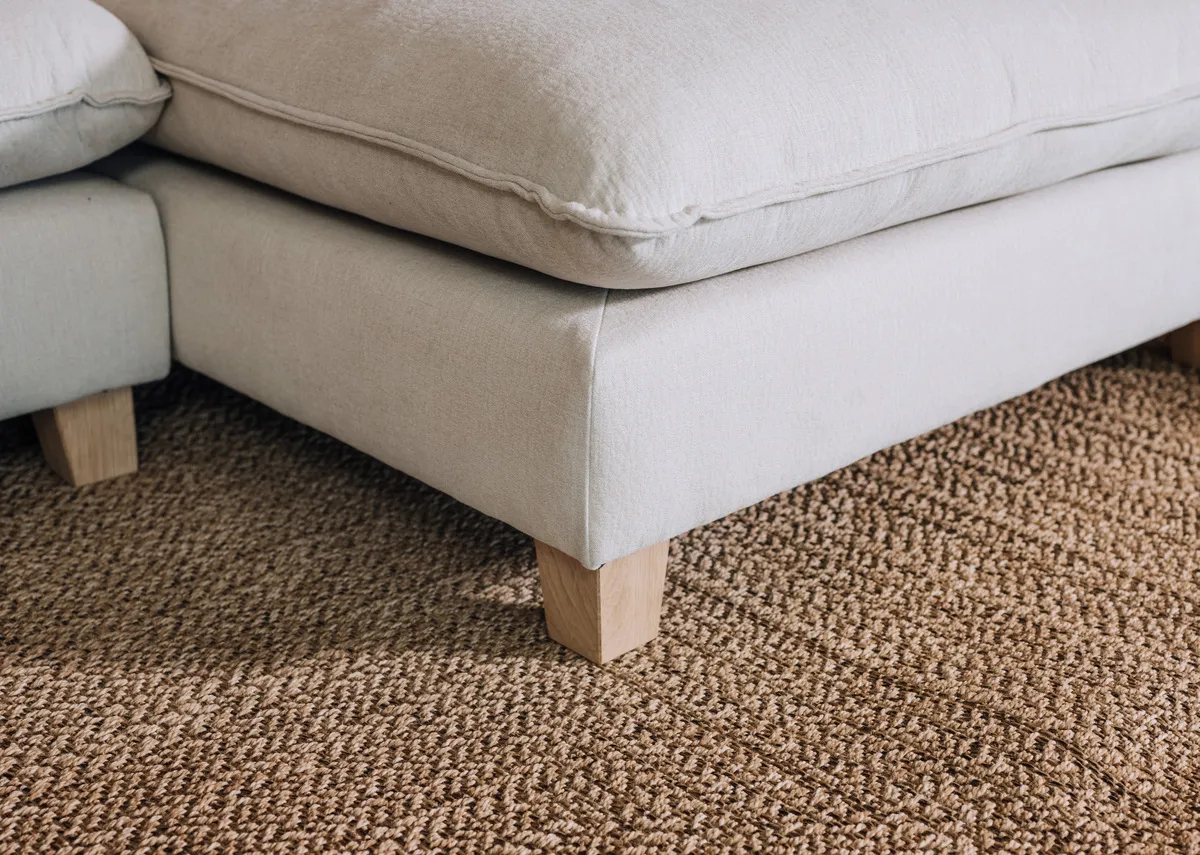 A closeup of the texture and design in the Kenzy rug beneath a Howth sofa.