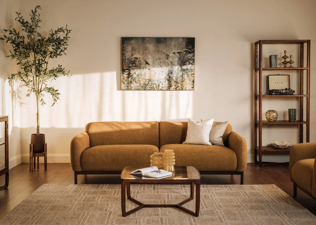 A lifetsyle image of the Loft gold sofa with Cameo bookcase & coffe etable with Benaoc vases.