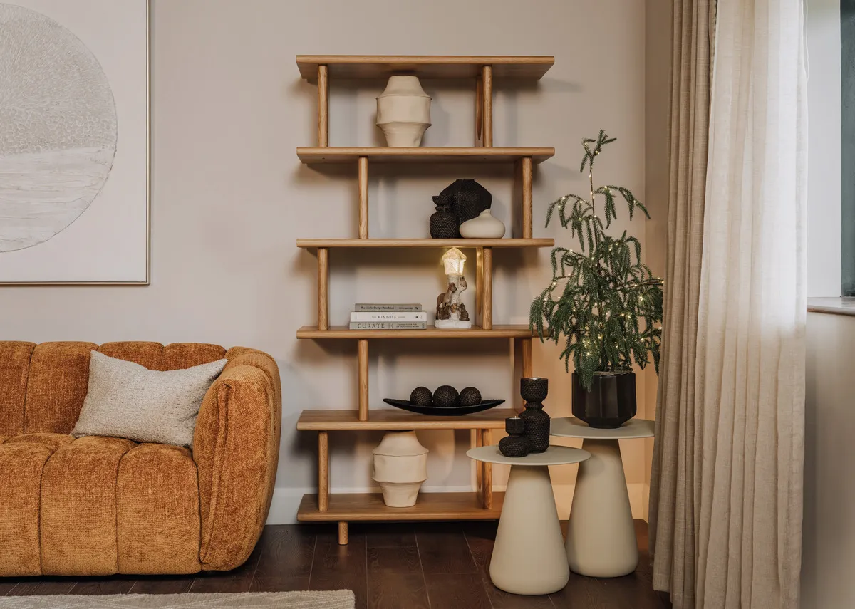 A lifestyle image of the Flow natural display unit with a selection of vases and ornaments tavish side table with fia plant.