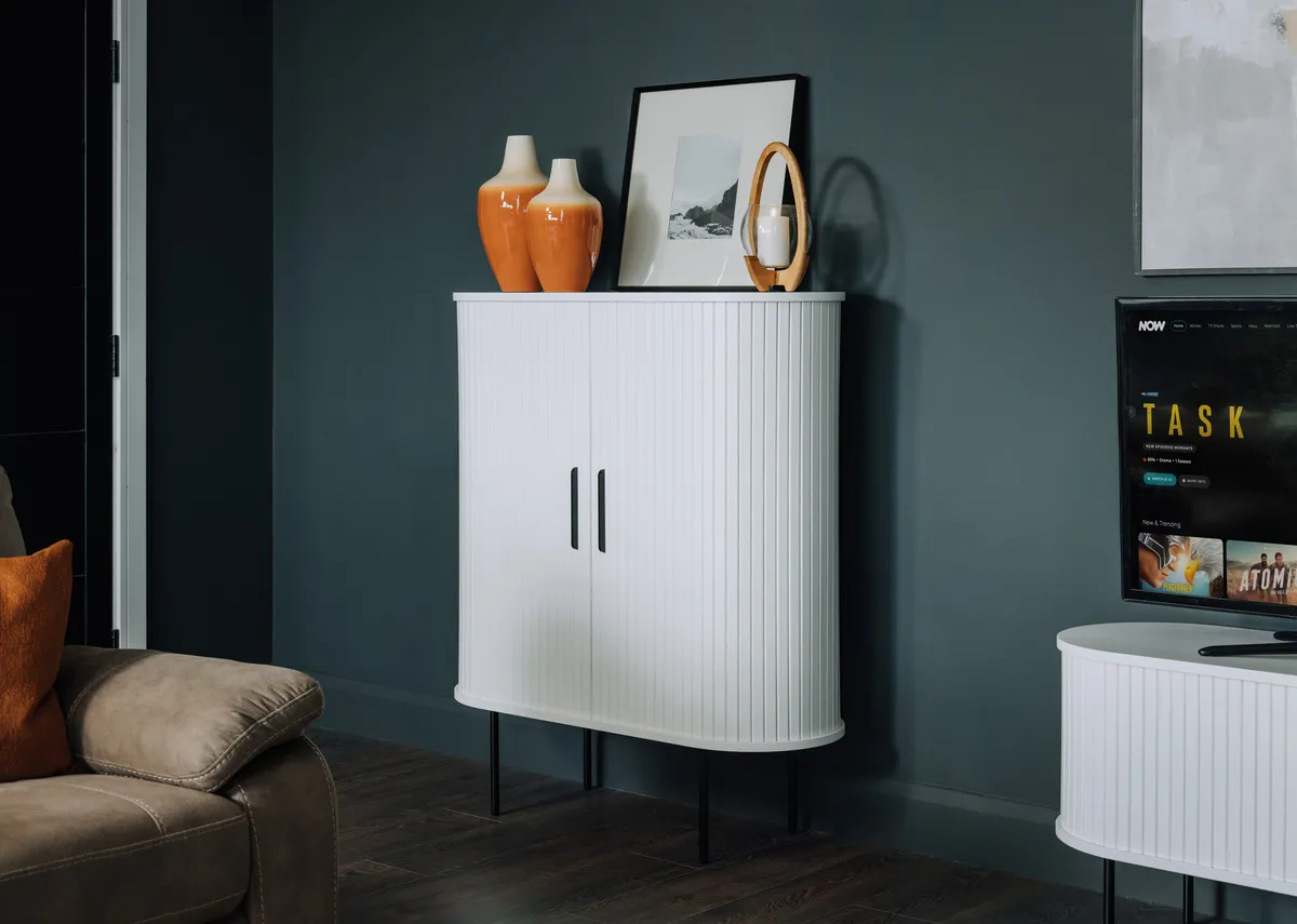 A lifestyle image of the Nikita sofa with Nola display cabinet in white oak