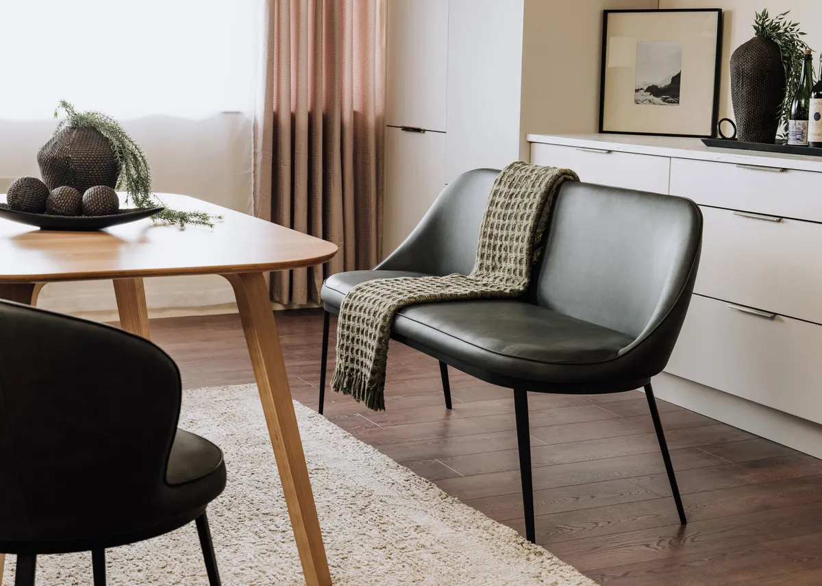 A lifestyle image of the Gain sofa bench in grey with the Anton dining table.