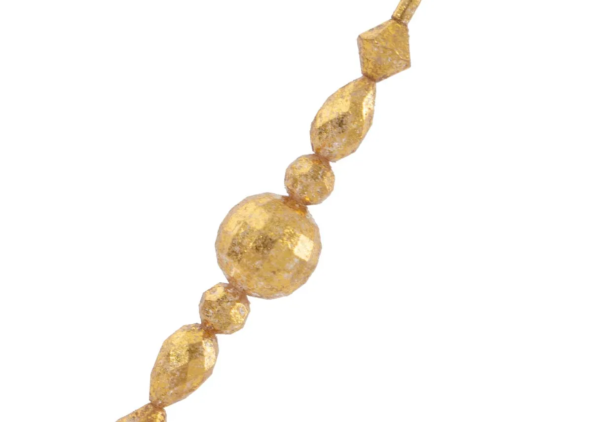 A close up of the textured gold beads on a gold diamond garland showcasing their faceted surfaces and glittering appearance.