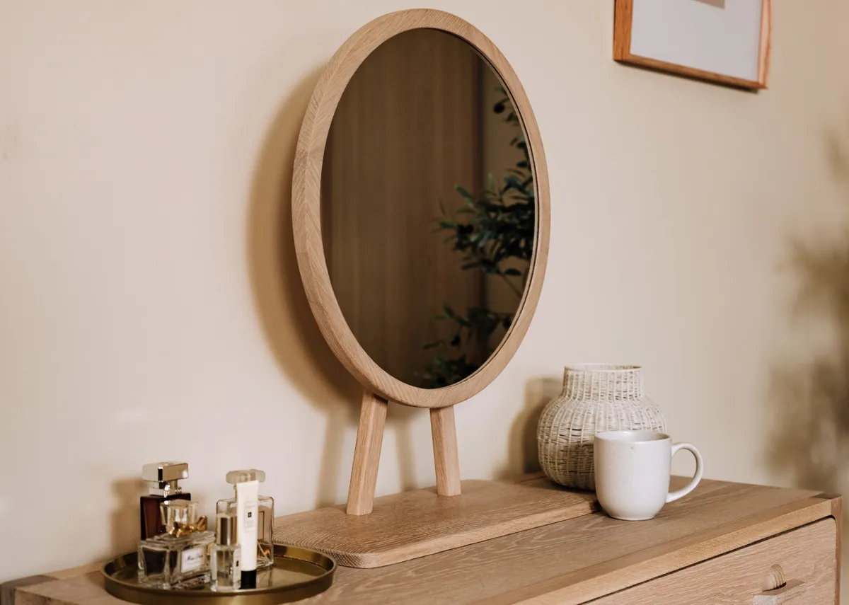 A lifestyle image of the Jay Dressing table with round mirror on table top.