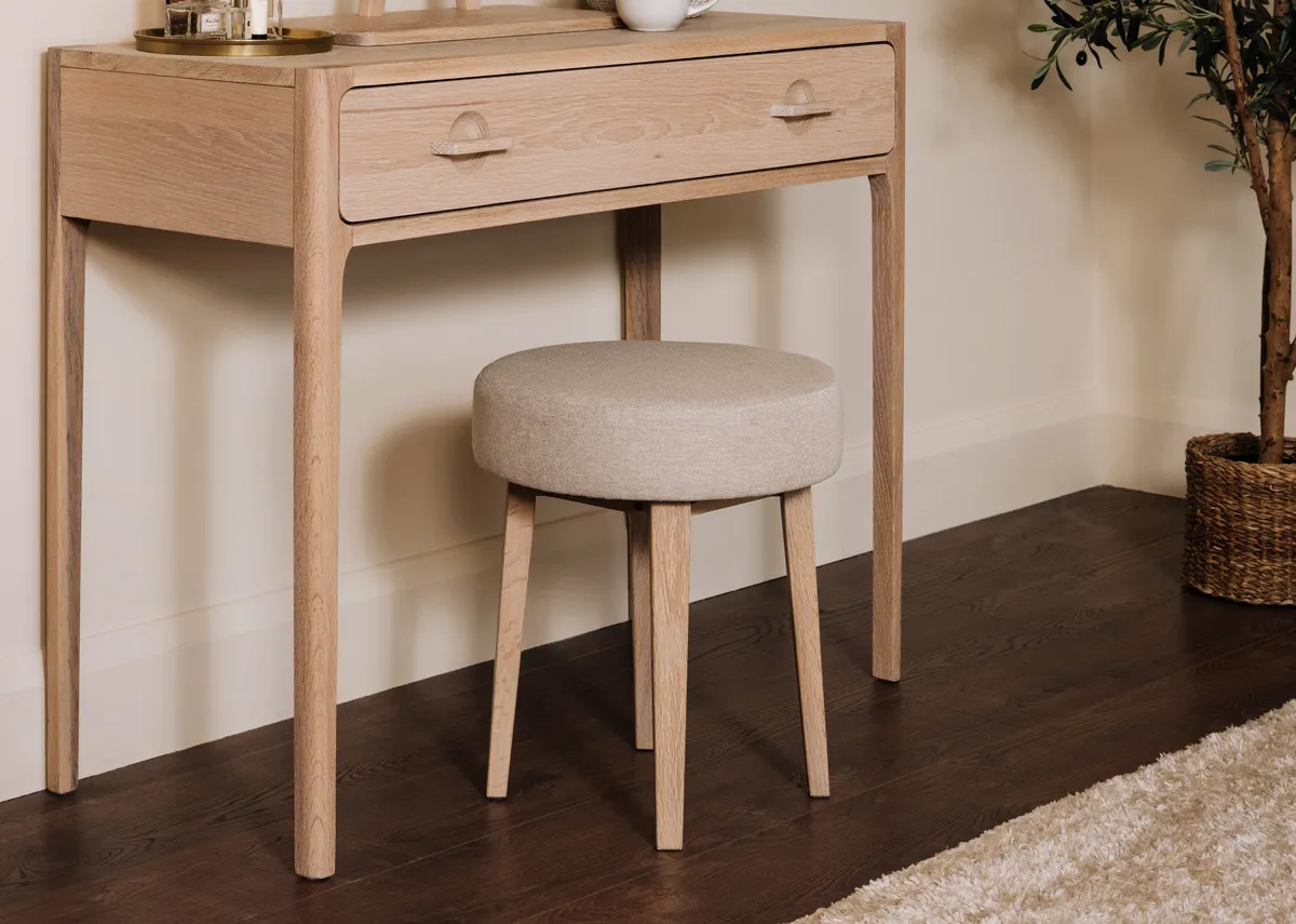 A lifestyle image of the Jay Dressing table with a closeup on the fabric  seat.