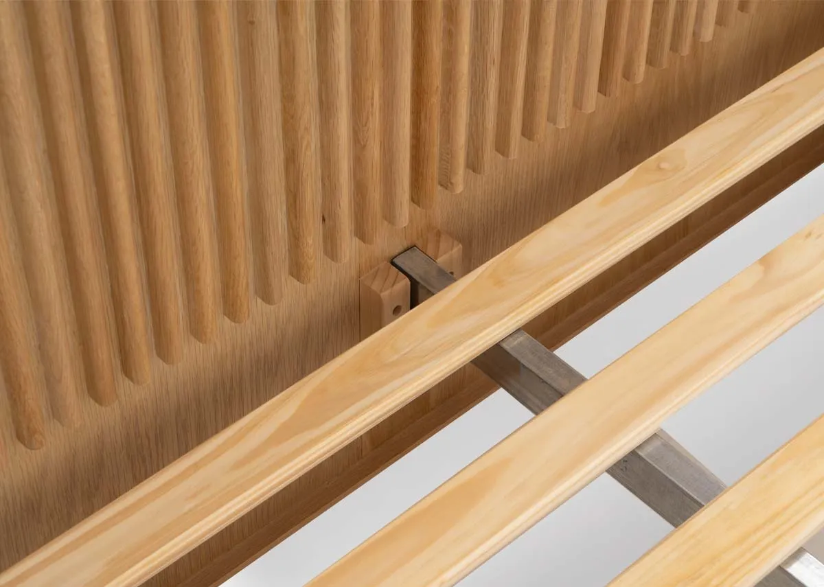 A natural oak bedframe with slatted base and headboard from EZ Livings Bradley range. Closeup of pine slats