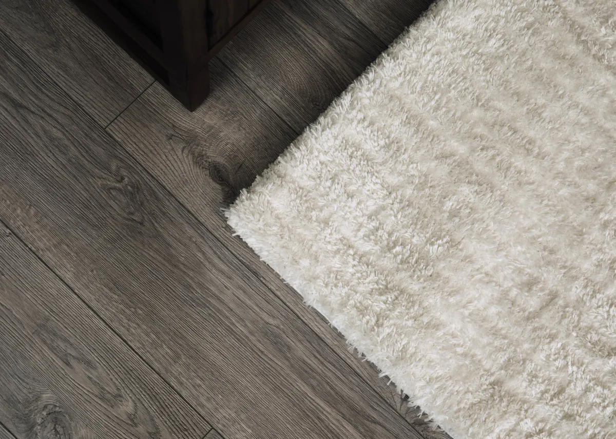 A lifestyle image of the Briony rug in a closeup on a wooden floor.