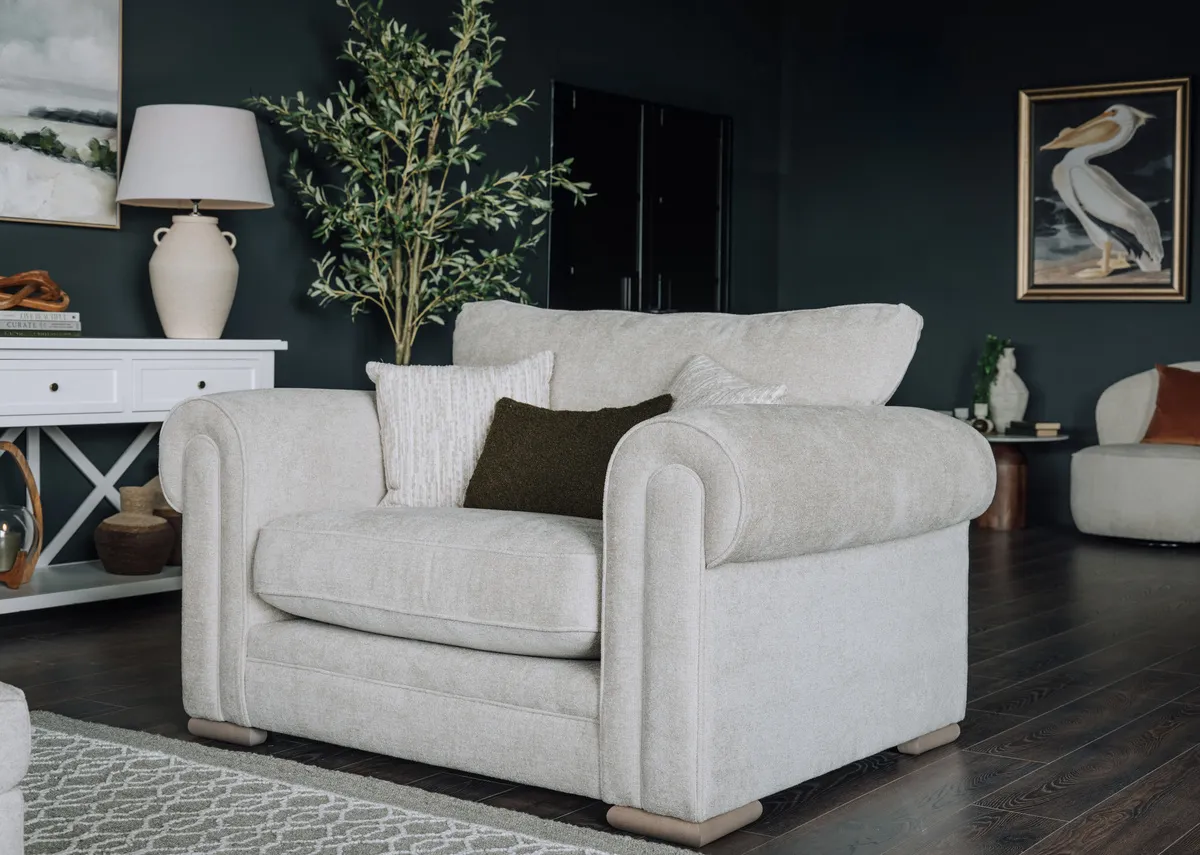 A lifestyle image of the Olivia snuggler with hampton console and pottery lamp.