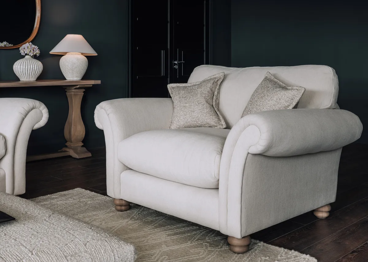 A lifetsyle image of the Palom cuddler with 2 scatter cushions and the Naxos console.