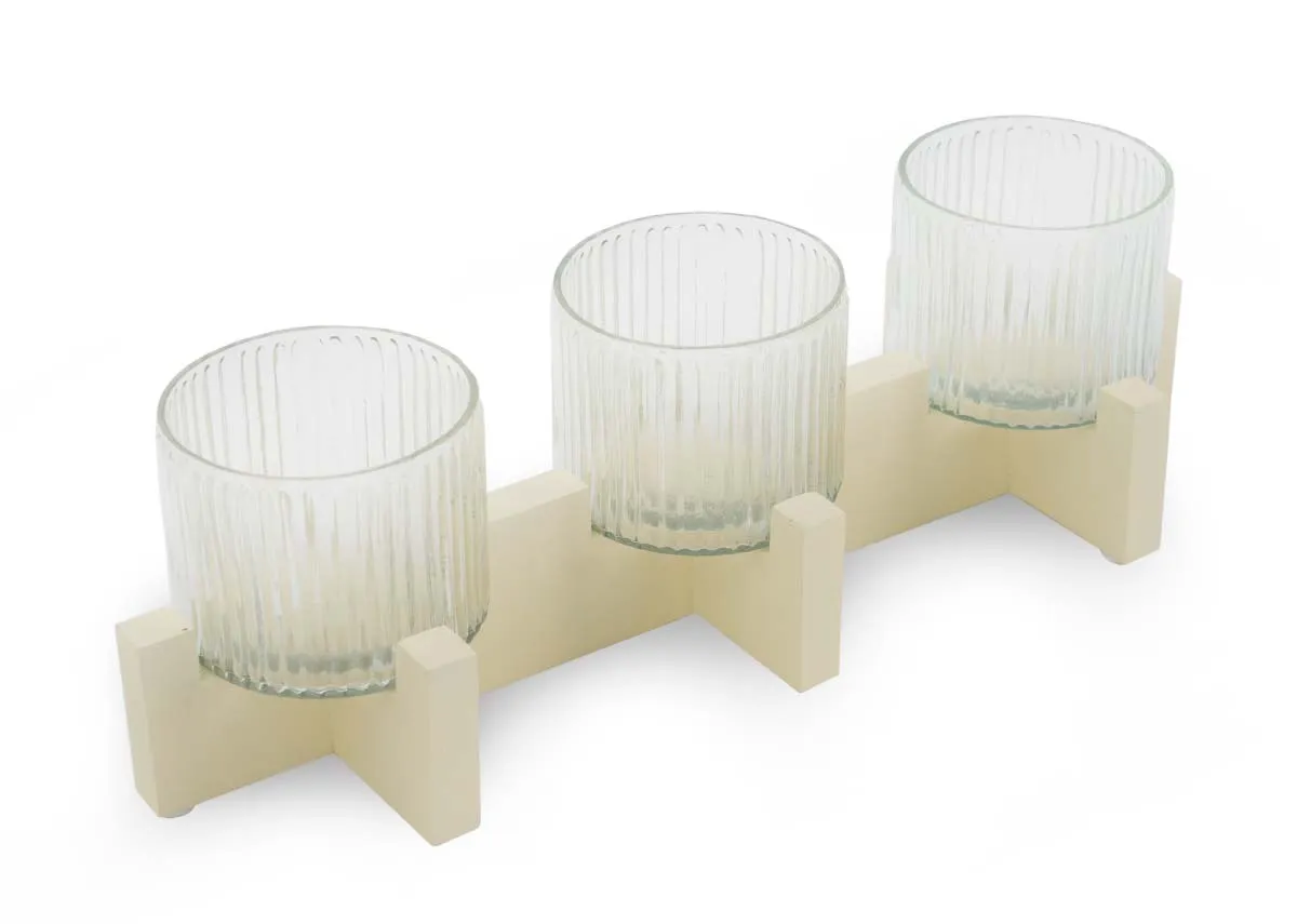 A cream stand with 3 ribbed glass candle holders from EZ Livings Piper range. Angled view.