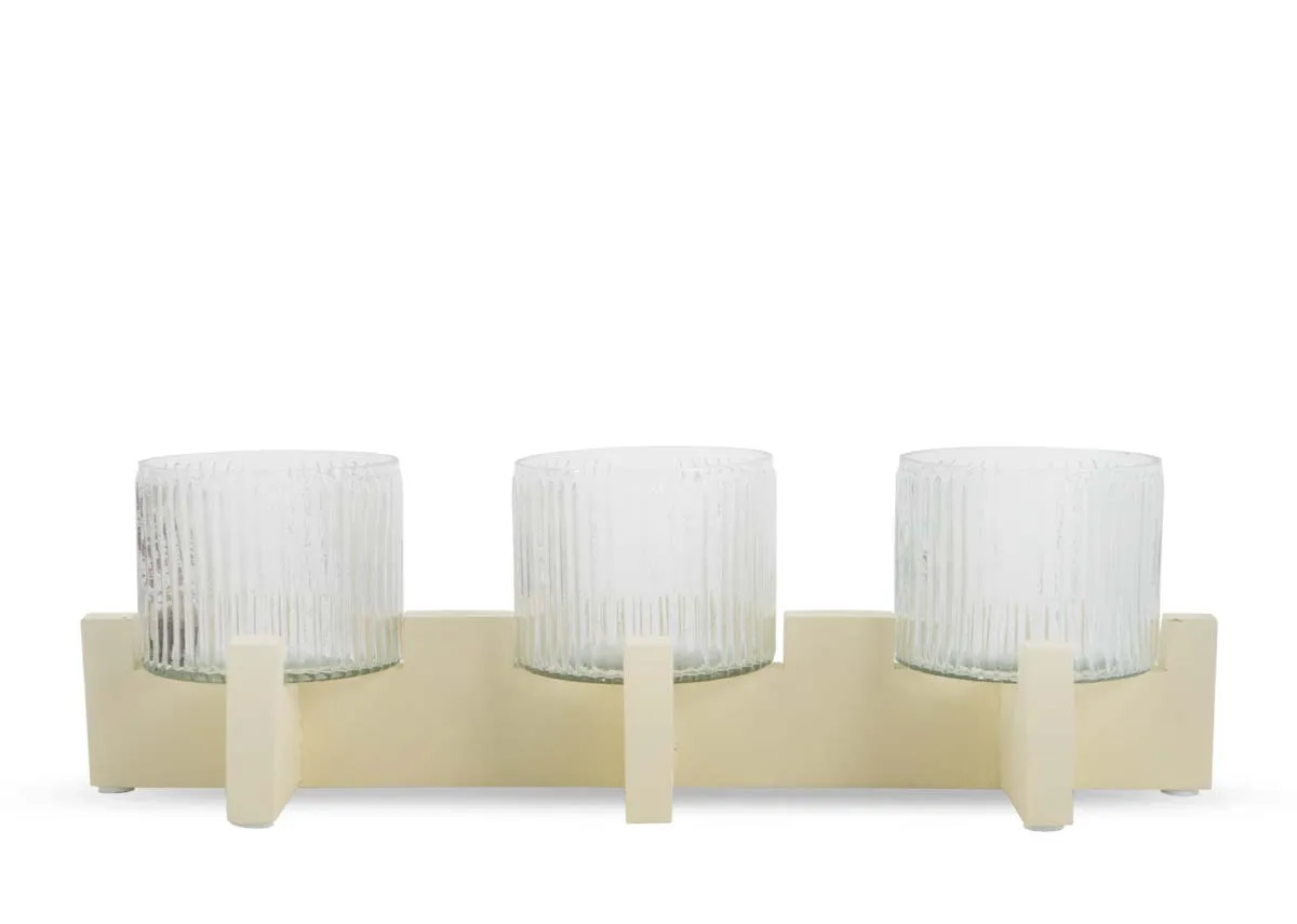 A cream stand with 3 ribbed glass candle holders from EZ Livings Piper range. Front view