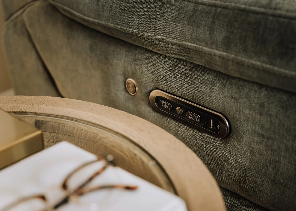 A lifetsyle image of the Elliot fabric recliner power control panel on the side arm.